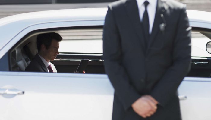 Bodyguard protecting politician in backseat of car