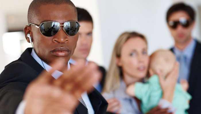 Shot of a bodyguard shielding his clients at a public event