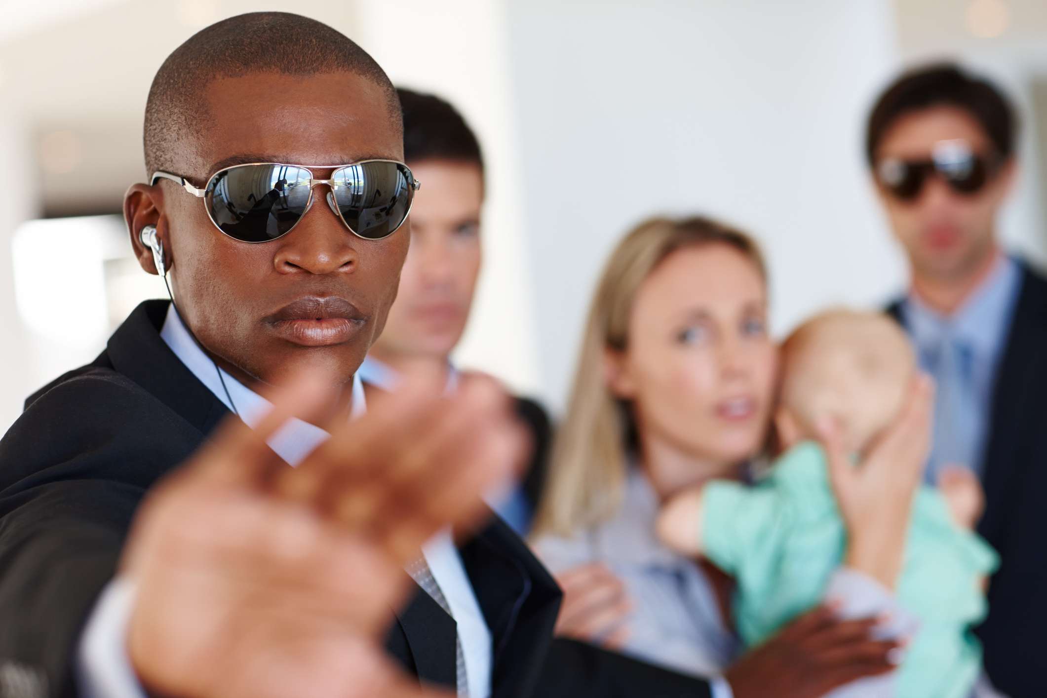 Shot of a bodyguard shielding his clients at a public event